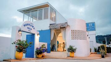A modern building with a blue door and a sign reading "Nontawa Villa & Cafe."