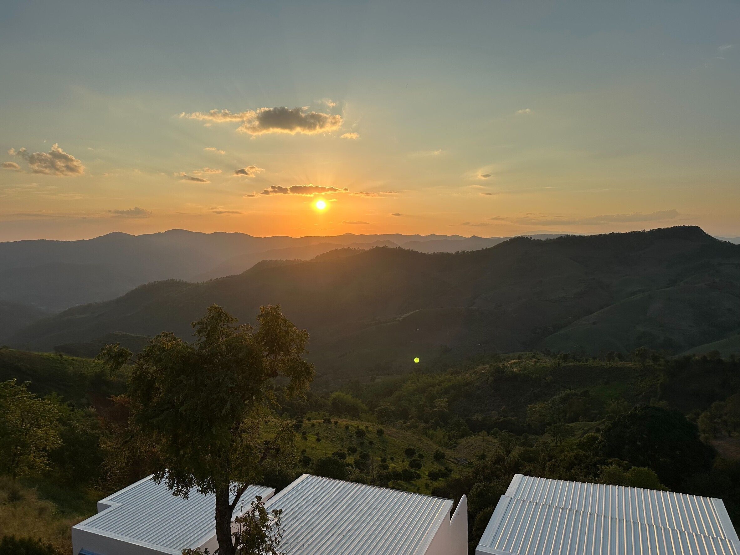 A view of a mountainous landscape with a sunset in the background.