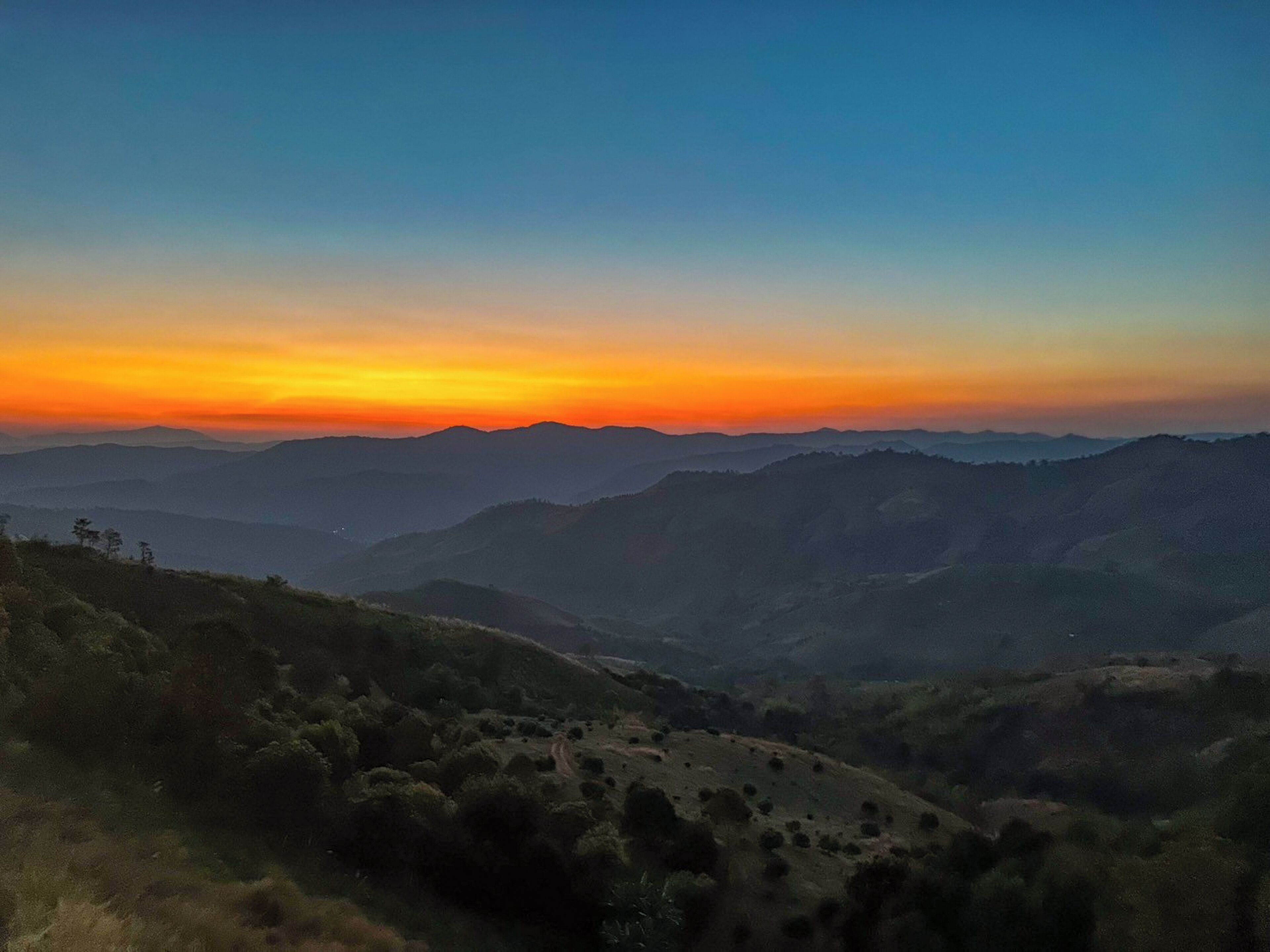 Un paisaje montañoso con un atardecer.