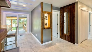 Un intérieur moderne avec un mur d’accent en bois, un tableau encadré et un escalier menant à un autre niveau.