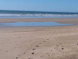 A beach with footprints and a puddle of water. - Apartment located a 5-minute walk from the beach (Saint-Hilaire-de-Riez)