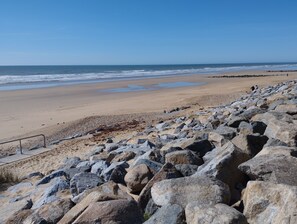 A rocky beach with a sandy area and a view of the ocean. - Apartment located a 5-minute walk from the beach (Saint-Hilaire-de-Riez)