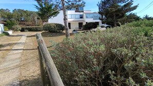 A two-story house with a visible front porch and a small garden area.