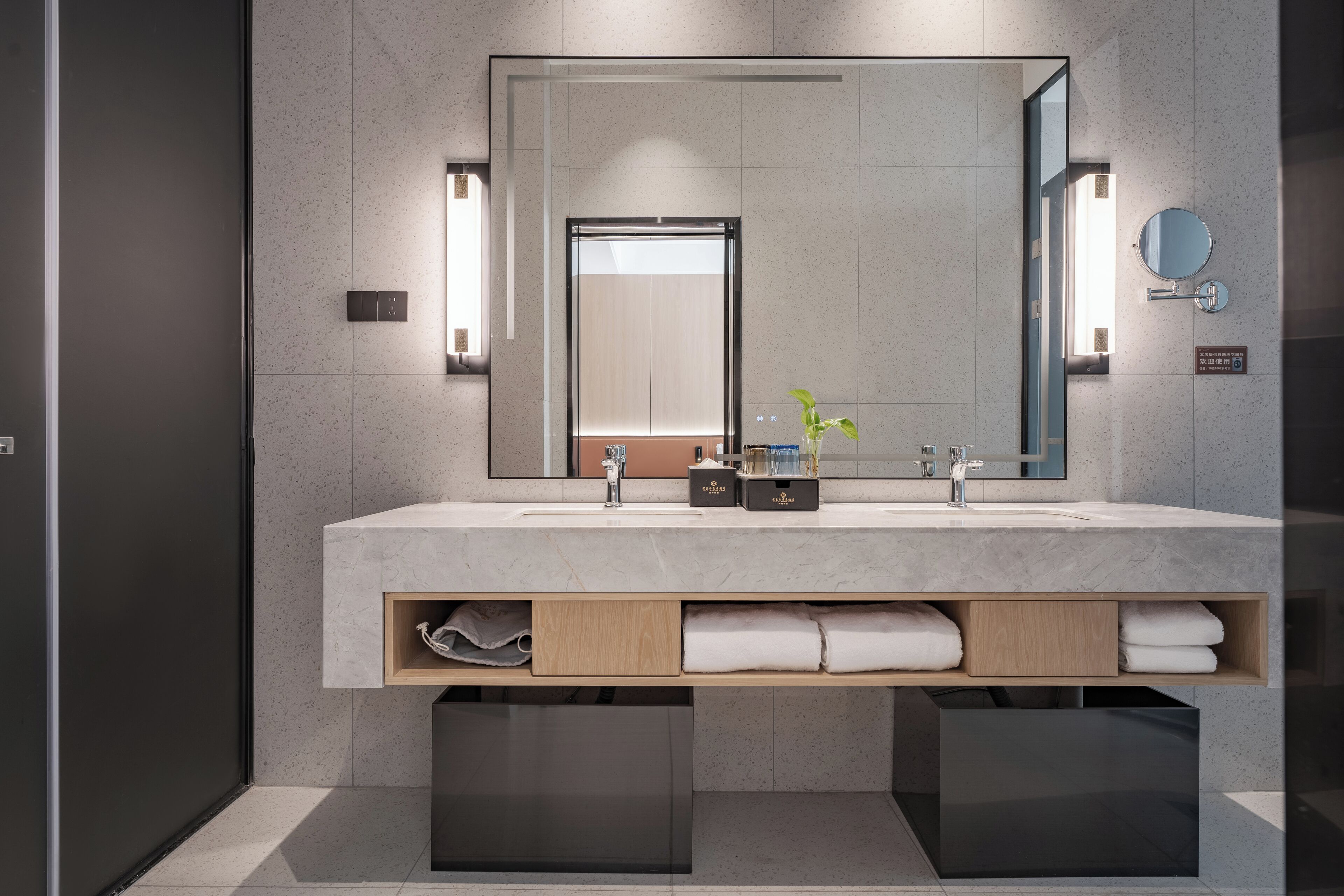 A modern bathroom with a large mirror, two sinks, and built-in storage.