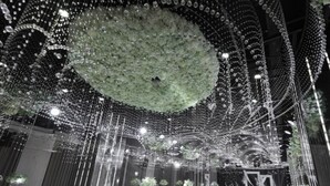 Un espace intérieur doté d’un aménagement circulaire des sièges, d’une composition florale centrale et de décorations suspendues.