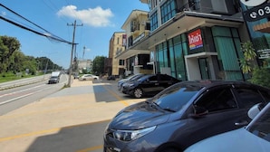 A street view with a modern building featuring a sign with 'my' and '03'. - Mybed Chonburi (Chonburi)