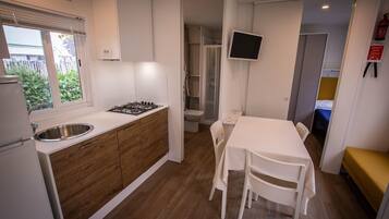 Coffee/tea maker, fridge, stovetop, dining table