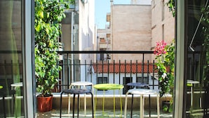 A balcony with a metal railing, potted plants, and outdoor tables. - Athens Smart 3-room Private Apartment (Athens)