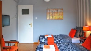 A room with two beds, a television, and a painting on the wall. - Athens Smart 3-room Private Apartment (Athens)