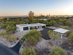 A modern house with a flat roof, a garage, and a covered patio area.