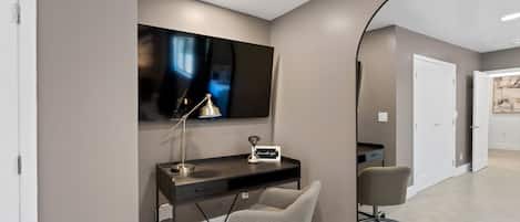 A modern office space with a desk, chair, and a large mirror.