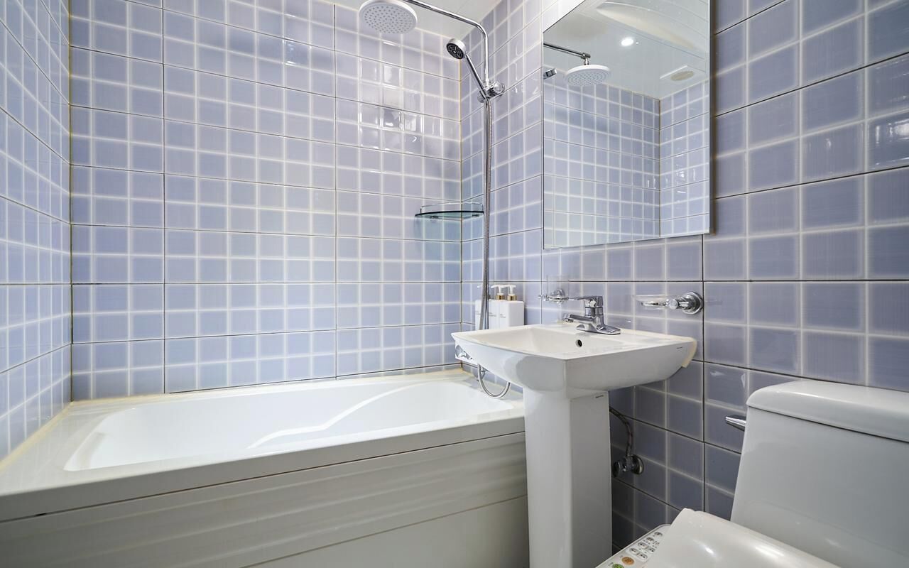 A modern bathroom with a bathtub, a sink, and a toilet.