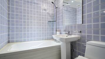 A modern bathroom with a bathtub, a sink, and a toilet.