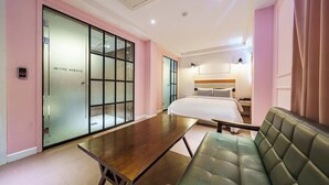 A hotel room with a bed, a desk, and a green sofa. - AVENUE HOTEL (Osan)