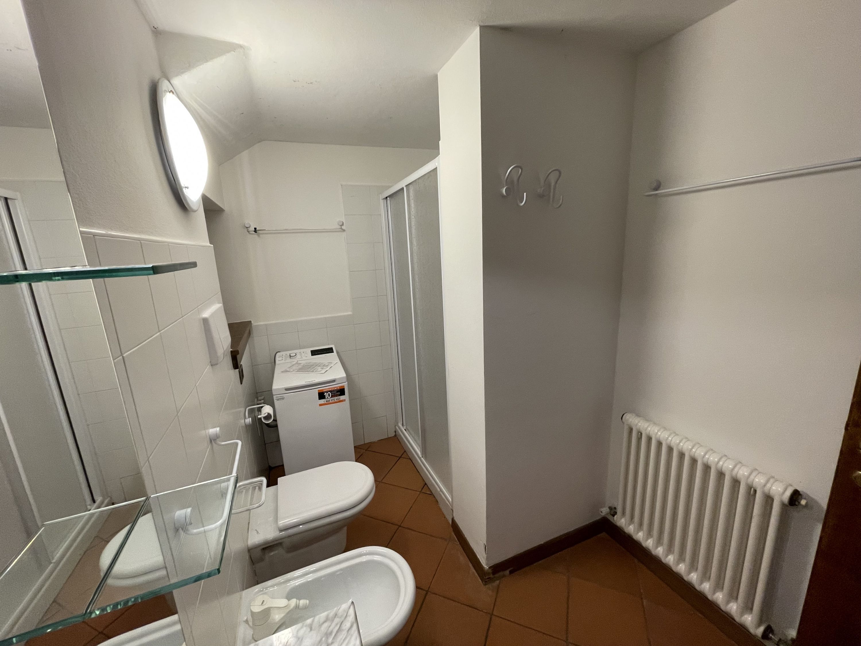Ein kleines Badezimmer mit Toilette, Bidet und Duschkabine aus Glas.