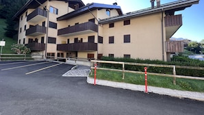 Un hotel a più piani con balconi, un'area di parcheggio e vista sul paesaggio circostante.