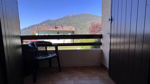 Un balcón con vista a una montaña y un edificio.