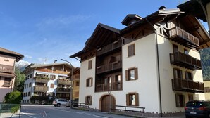 A multi-story building with balconies, a wooden facade, and a clear sky. - 032 Luminosa Mansarda Pinzolo (Pinzolo)