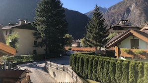 A residential area with houses, a paved street, and mountains in the background. - 012 Trilocale a due Passi Dagli Impianti Pinzolo (Carisolo)