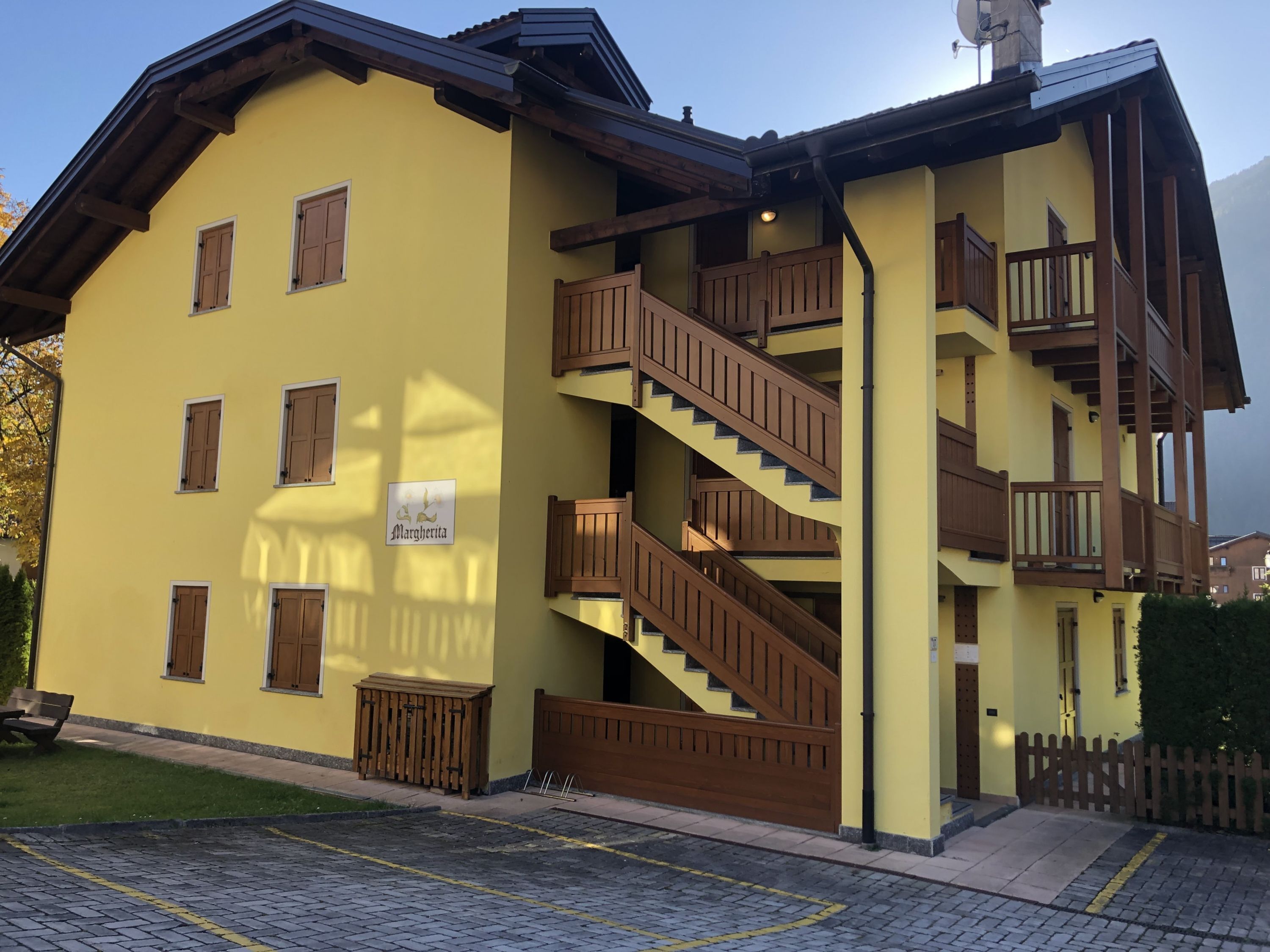 A multi-story building with wooden balconies and a staircase.