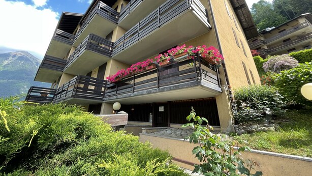 Un immeuble à plusieurs étages doté de balcons, dont certains sont ornés de jardinières.