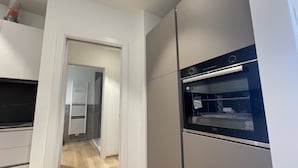 Una cucina moderna con forno integrato e microonde separato.