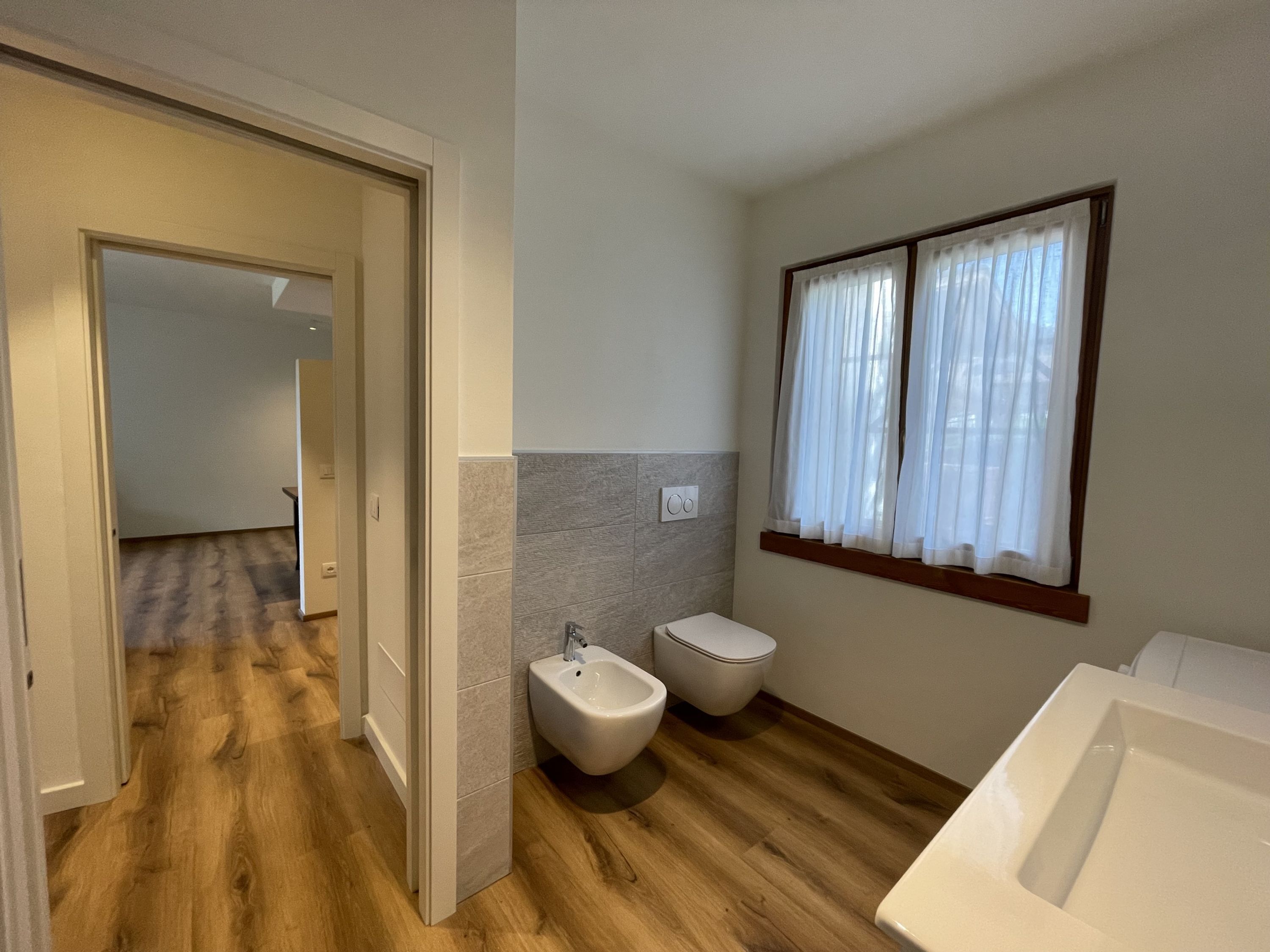 A bathroom with a bidet, toilet, and bathtub.