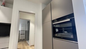 Una cucina moderna con forno integrato e microonde separato.