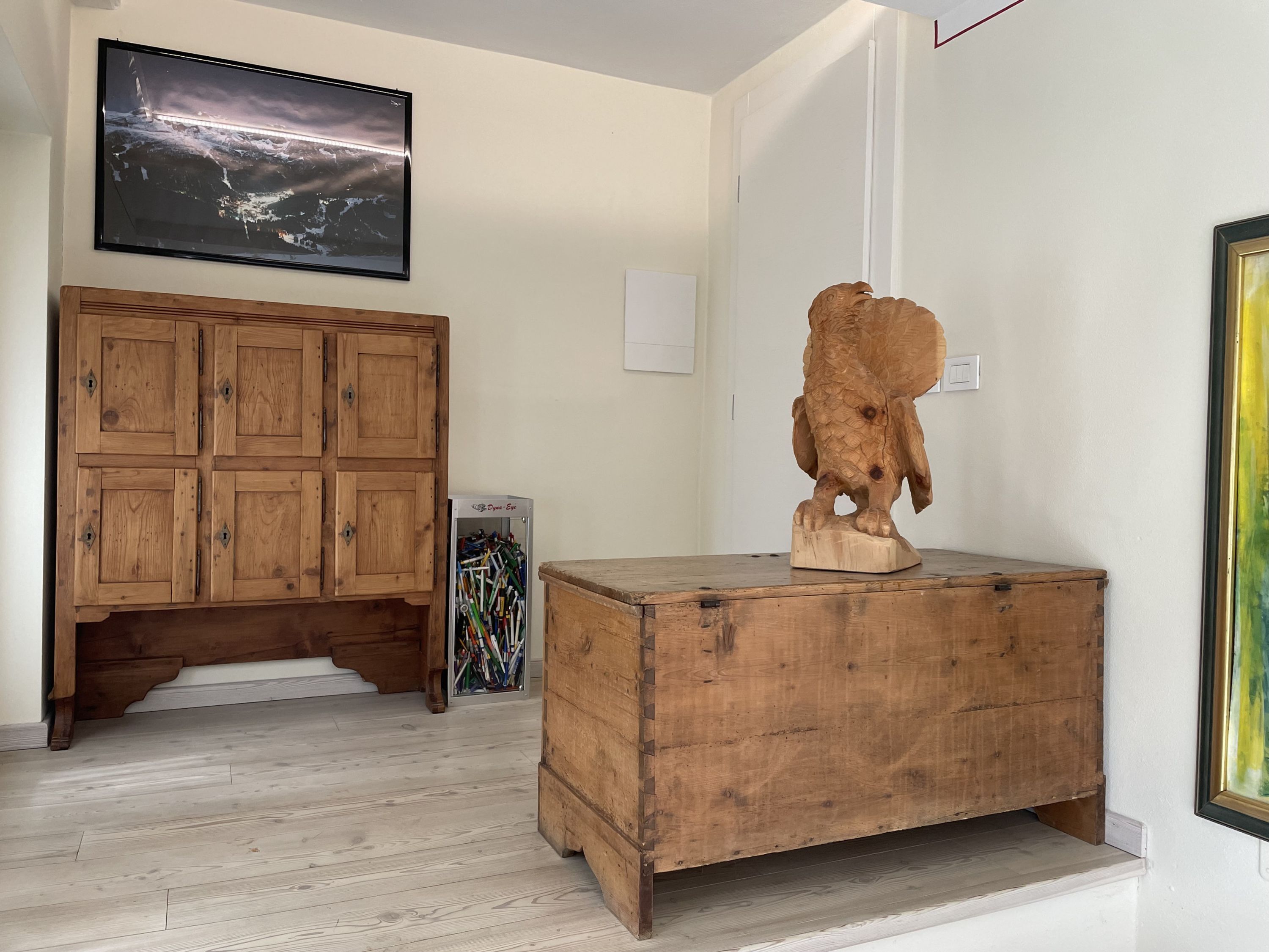 Une pièce comprenant un meuble en bois, une commode en bois et un tableau encadré accroché au mur.