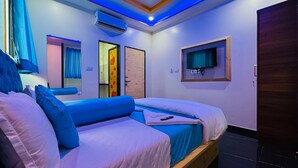 A modern bedroom with a large bed, a TV mounted on the wall, and an air conditioning unit. - Welcome Star (Mumbai)