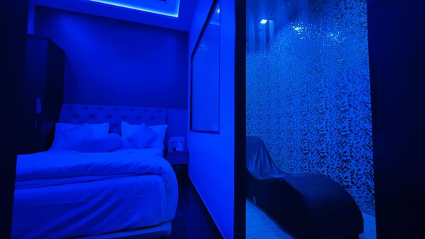 A modern bedroom with a bed, bedside table, and a patterned wall.