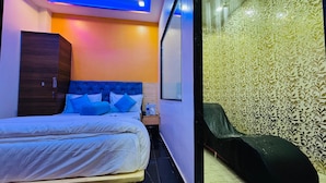 A hotel room with a bed, a wardrobe, a nightstand, and a chair. - Welcome Star (Mumbai)