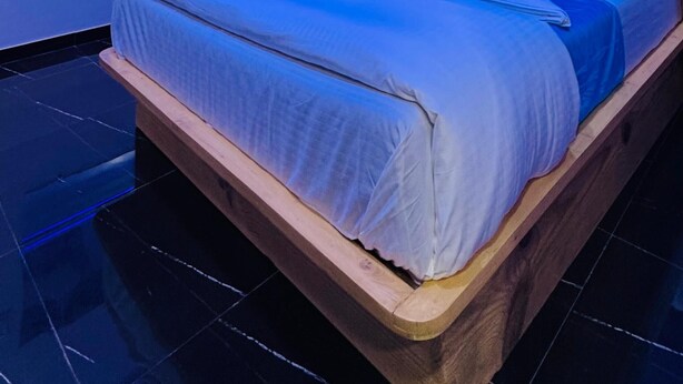 A modern bedroom with a bed, a wardrobe, and an air conditioning unit. - Welcome Star (Mumbai)