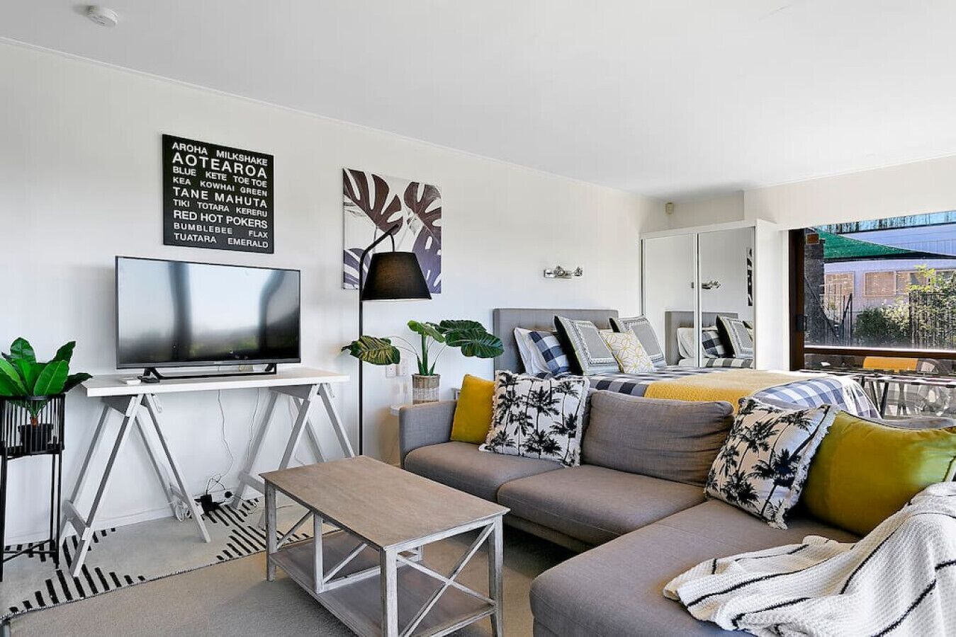 A modern living room with a flat-screen TV, a sofa, and a coffee table.
