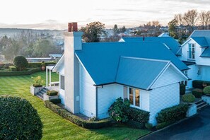 A modern house with a blue roof, a chimney, and a well-maintained lawn.