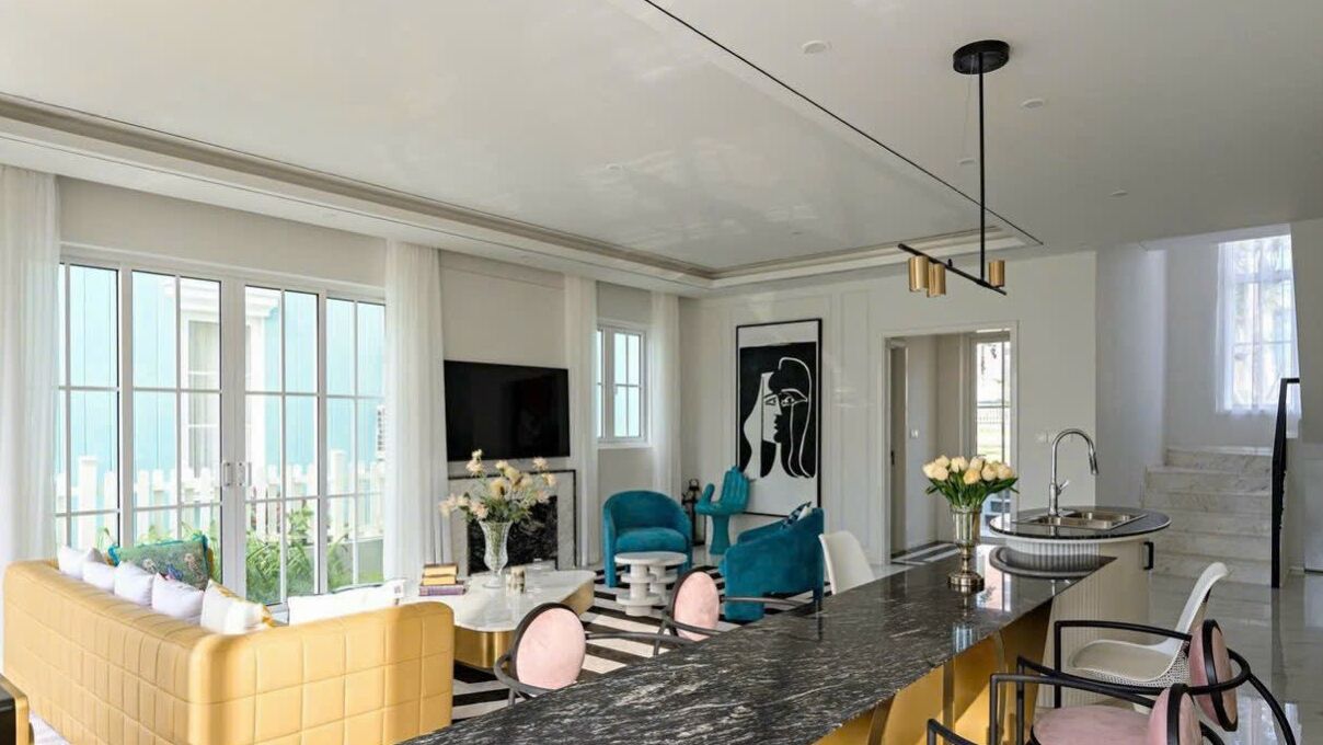 A modern kitchen with a marble countertop, a built-in oven, and a large window.
