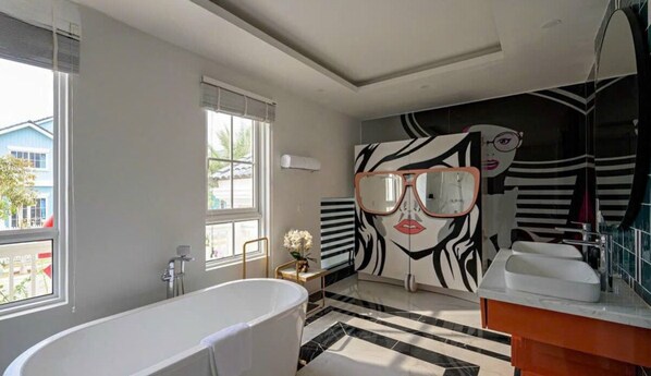 A modern bathroom with a freestanding bathtub, a large mirror, and a zebra print wall. - Refined Phan Thiet - Novaworld Villas (Tien Thanh)