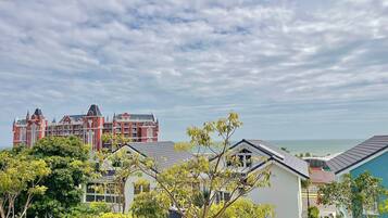A coastal view with a large red building and smaller houses.