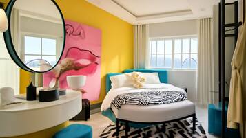 A modern bedroom with a bed, a bedside table, a mirror, and a large window.