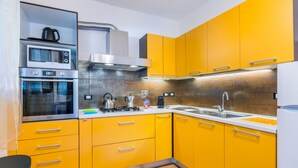 Eine moderne Küche mit gelben Schränken, Edelstahlgeräten und Holzboden.