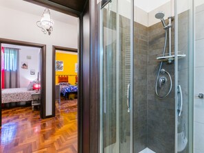 A modern bathroom with a glass shower enclosure, a handheld showerhead, and a handheld showerhead. - Quiet place by Interhome (Greve in Chianti)