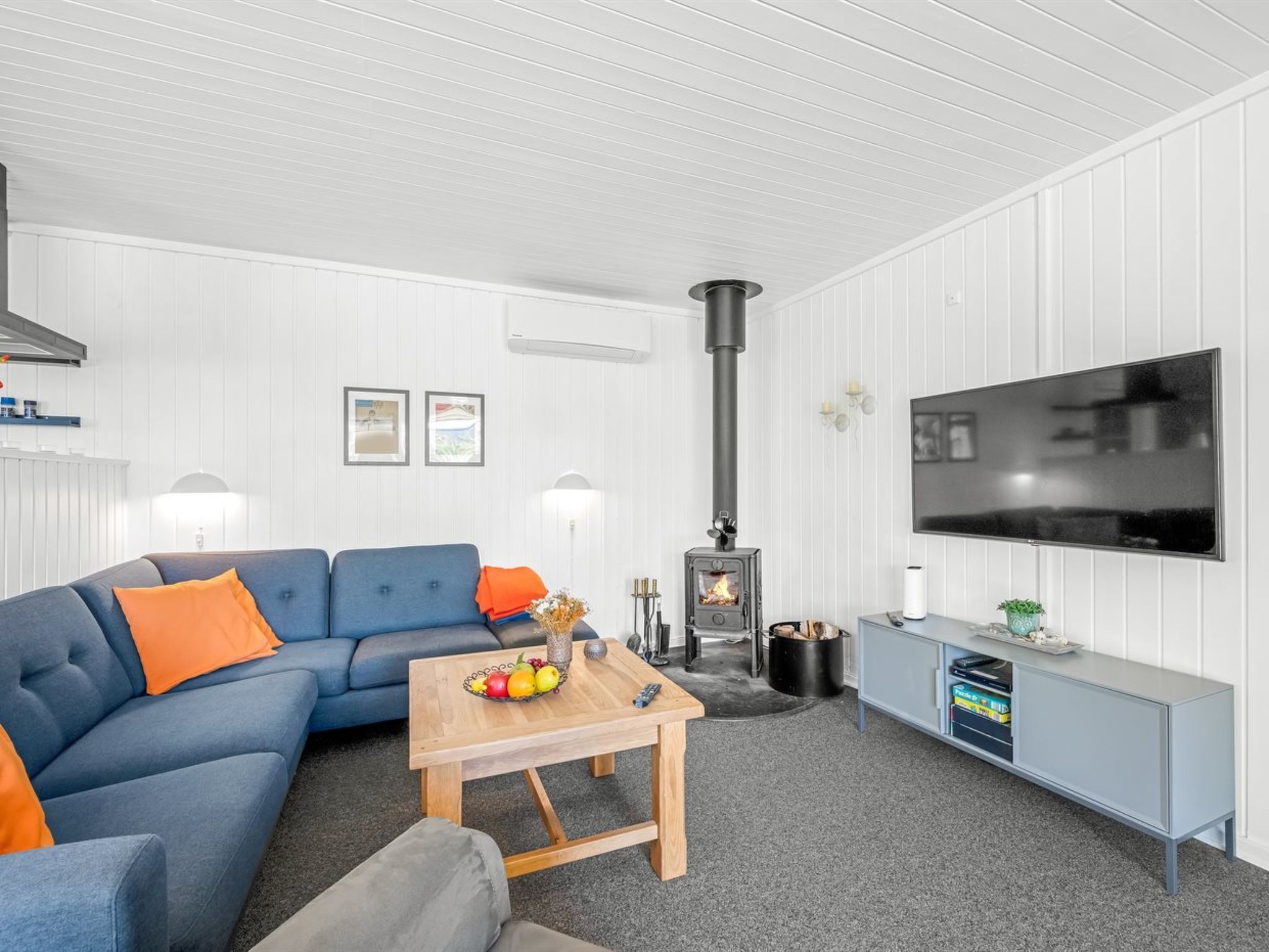 Ein Wohnzimmer mit einer Couch, einem Couchtisch, einem Fernseher, einem Kamin und einem Schrank.