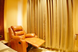 Ein Zimmer mit Massagegerät, einem Bett und einem Vorhang.
