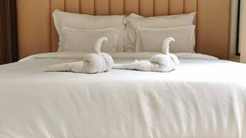 A bed with a headboard, pillows, and two swan-shaped decorations.