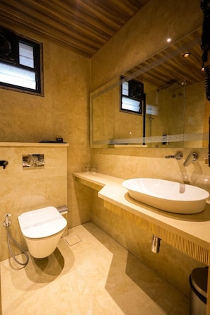A modern bathroom with a toilet, sink, and mirror. - The Grand Sun City Hotel & Resort (Bhopal)