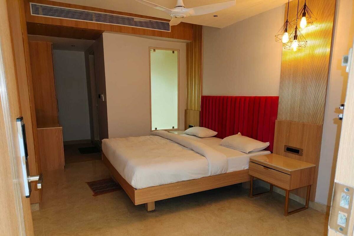 A bedroom with a bed, bedside table, and a ceiling fan.