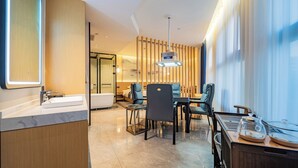 A modern hotel room with a bathroom, a dining area, and a large window. - ZEHAI HOTEL (Xi'an)