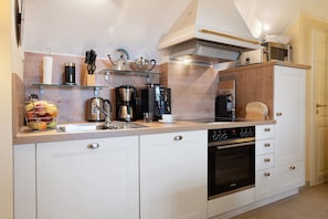 Une cuisine équipée d’un évier, d’une cuisinière, d’un four à micro-ondes et de divers appareils électroménagers.