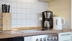 Une cuisine équipée d’une machine à café, d’un grille-pain et d’un bloc à couteaux.