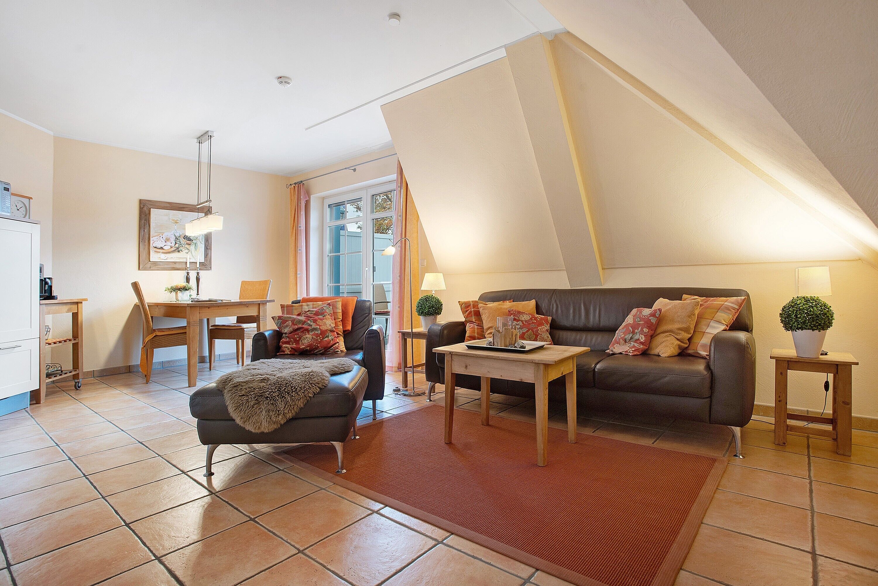 Een woonkamer met een bank, een salontafel, een eettafel en een keukenhoek.